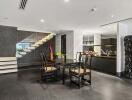 Modern dining area with a view of the kitchen and staircase