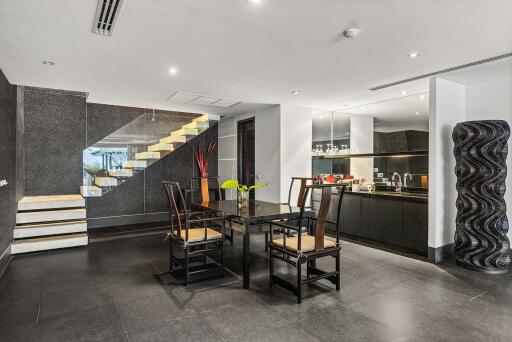 Modern dining area with a view of the kitchen and staircase