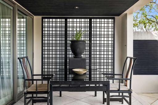 Modern outdoor patio area with black furniture and decorative elements