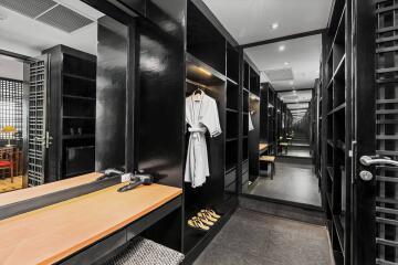 Spacious walk-in closet with built-in wooden shelves and mirrors