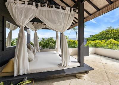 Outdoor bedroom area with canopy bed and garden view