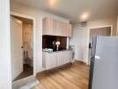 Small modern kitchen with wooden flooring and gray cabinets