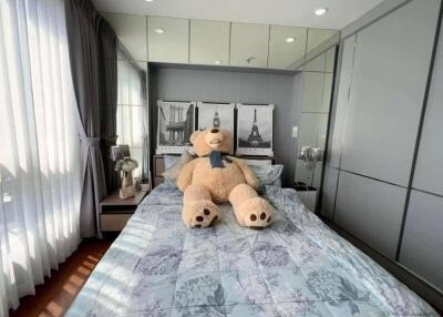 Cozy bedroom with large teddy bear on the bed