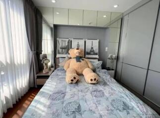 Cozy bedroom with large teddy bear on the bed