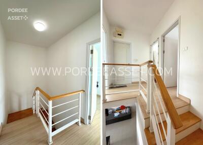 Staircase and hallway with wooden handrail and white walls