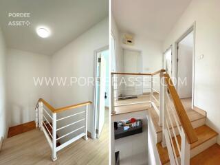 Staircase and hallway with wooden handrail and white walls