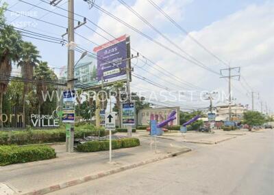 Street view of a residential area with signage and power lines