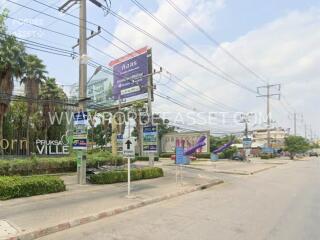 Street view of a residential area with signage and power lines