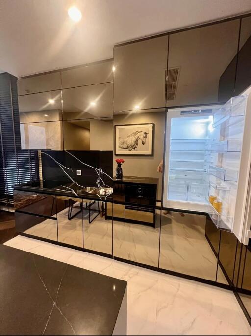 Modern kitchen with mirrored cabinets and open refrigerator