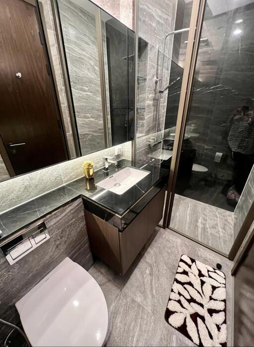 Modern bathroom with vanity, shower, and toilet