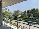 A balcony with a view of trees and a street