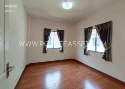 Empty bedroom with wooden flooring and windows