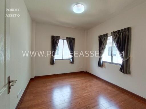 Empty bedroom with wooden flooring and windows