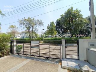 Exterior entrance to a gated property with trees and greenery