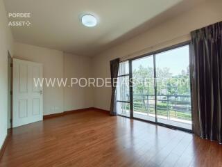 Spacious living room with wooden flooring and large sliding glass doors leading to a balcony