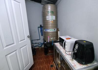 Utility room with water tank and kitchen appliances