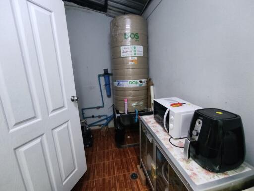 Utility room with water tank and kitchen appliances