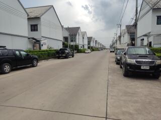 Street view of a residential neighborhood with lined white houses