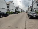 Street view of a residential neighborhood with lined white houses