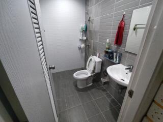 Modern bathroom with gray tiles, sink, and toilet