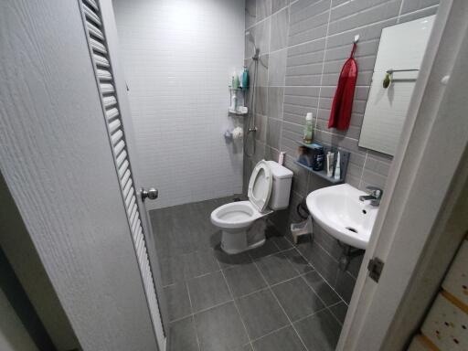 Modern bathroom with gray tiles, sink, and toilet