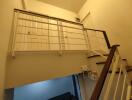 Indoor staircase with a white railing and a view of the upper landing and doors