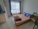 Neatly decorated bedroom with a window providing natural light