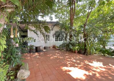 Spacious outdoor area with tiled flooring and lush greenery