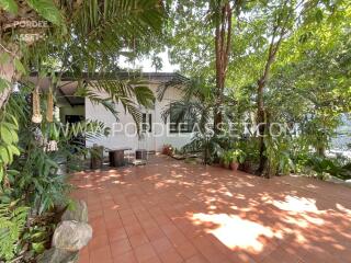 Spacious outdoor area with tiled flooring and lush greenery