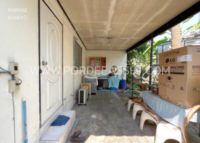 Covered utility area with washing machine and storage