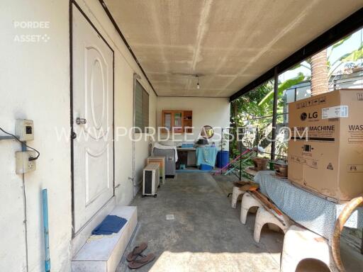 Covered utility area with washing machine and storage