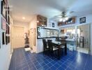 Dining area in a kitchen with blue tile flooring and a ceiling fan