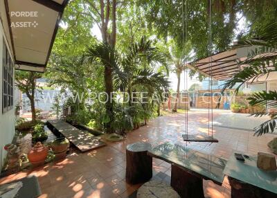 Outdoor seating area with lush greenery and a swing