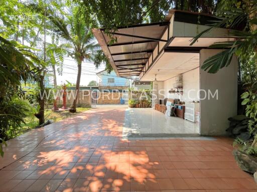 Covered outdoor patio with tiled flooring and garden