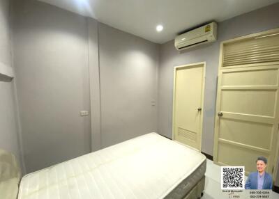 Bedroom with bed, air conditioning unit, and door