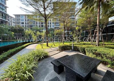 Modern residential complex with landscaped greenery and seating area