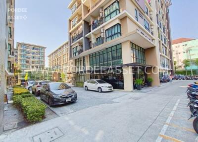 Exterior view of a modern residential building with parking area