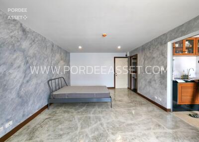 Bedroom with gray wall and a bed without mattress