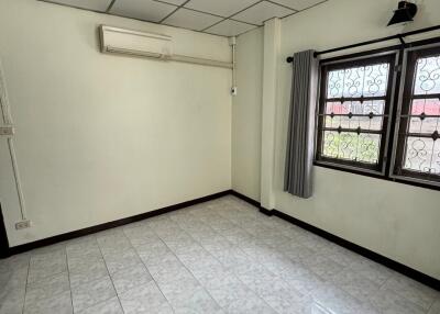 Spacious bedroom with tiled floor and air conditioning