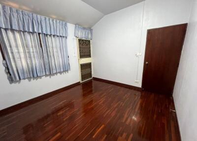 Spacious bedroom with wooden floors and natural light