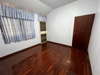 Spacious bedroom with wooden floors and natural light