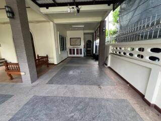 Spacious covered outdoor area with bench and fenced siding