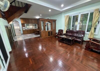 Living room with wooden furniture and connected kitchen