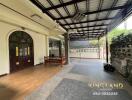 Covered outdoor patio area with wooden bench and tiled flooring