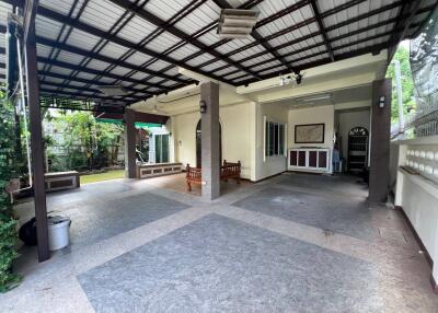 Covered outdoor patio area with tiled flooring and seating