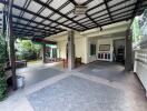 Covered outdoor patio area with tiled flooring and seating