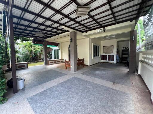 Covered outdoor patio area with tiled flooring and seating