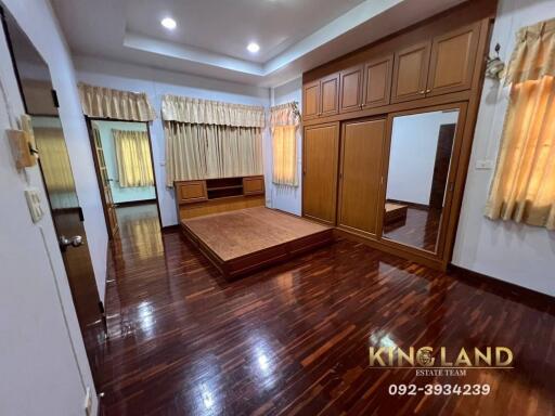 Spacious bedroom with wood flooring and built-in wardrobe