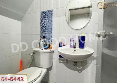 Bathroom with toilet, sink, mirror, and toiletries