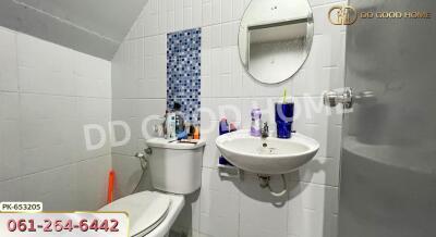 Bathroom with toilet, sink, mirror, and toiletries